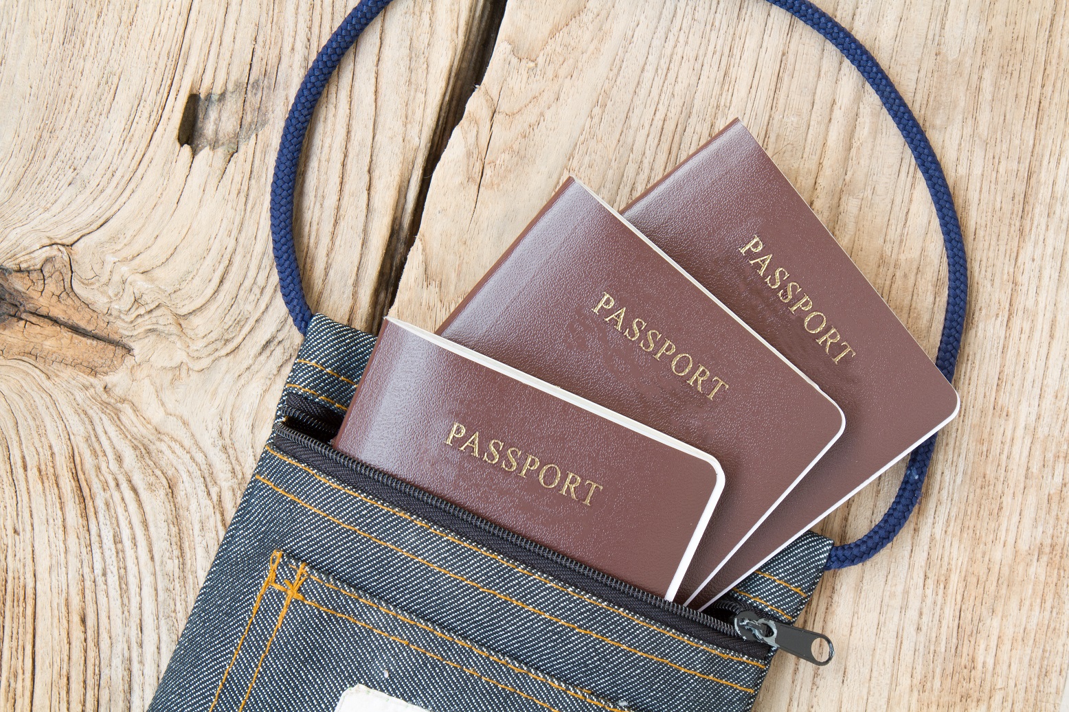 Passport in fabric bag on wood table. top view.